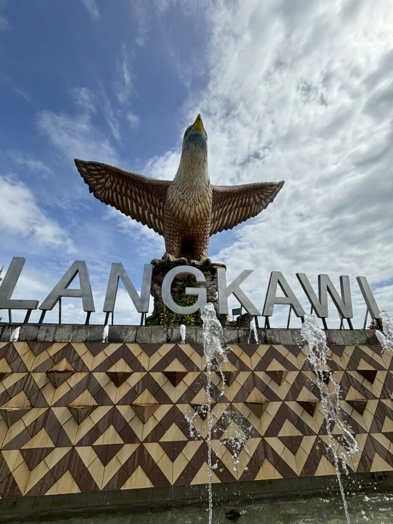 イーグルスクエアのLANGKAWIの文字の上で翼を広げる鷲の像と噴水