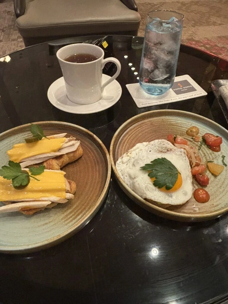 ランカウイから戻った夜に食べたトーストと目玉焼きの皿、紅茶と水