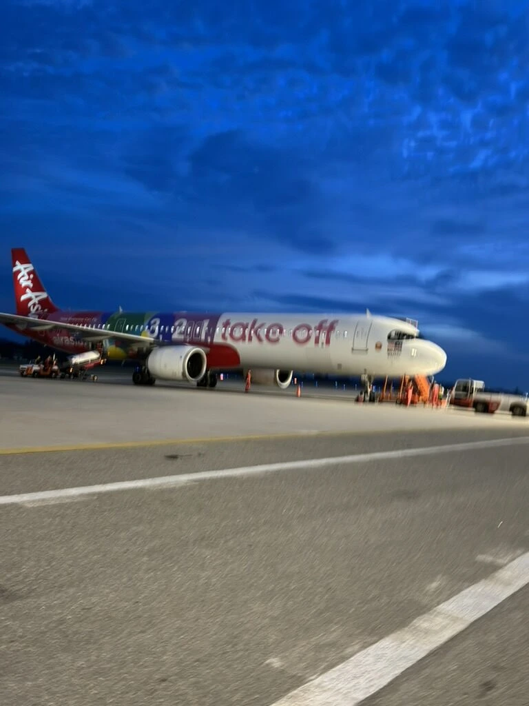 ランカウイ空港の夕暮れの駐機場に止まるエアアジアの特別塗装機