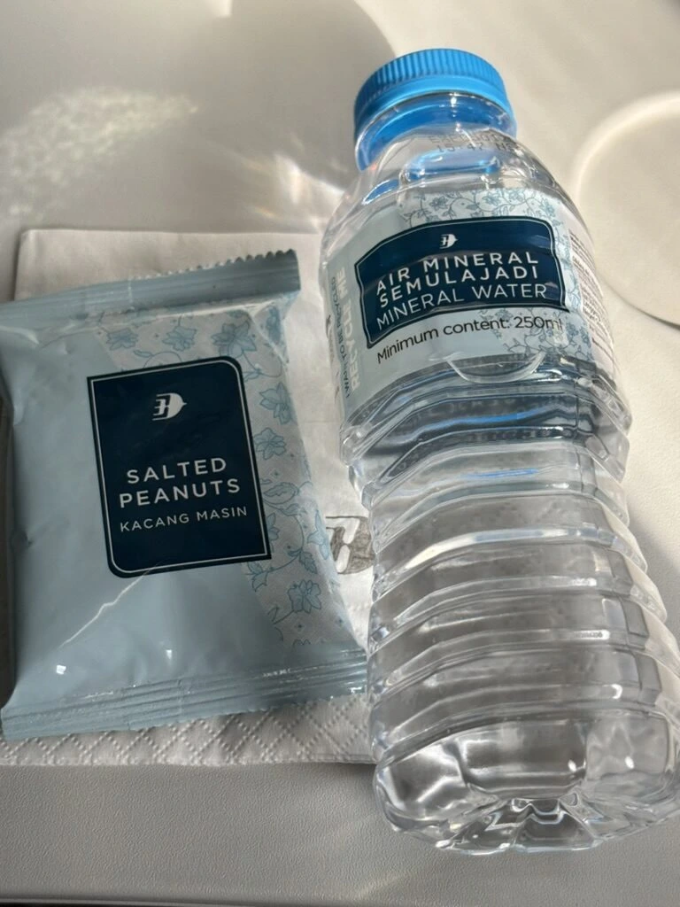 MH1432の機内で配られたSALTED PEANUTSの袋とミネラルウォーター
