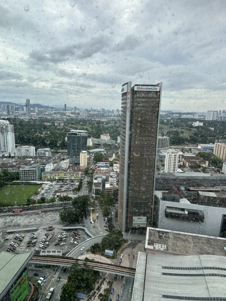 AC Hotel Kuala Lumpurの雨粒のついた窓越しに見たクアラルンプールの高層ビル