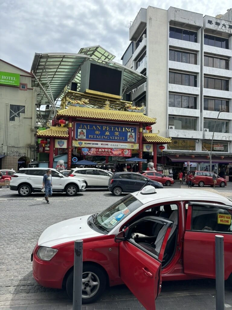 クアラルンプール・チャイナタウンのJALAN PETALINGの門と赤いタクシー