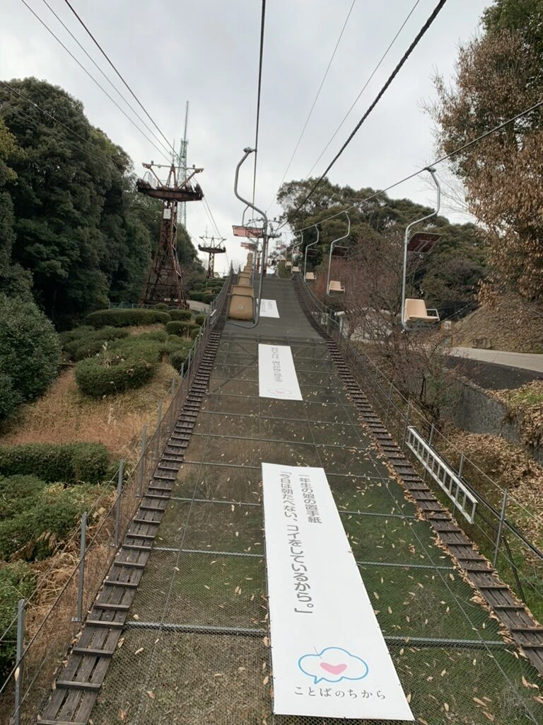松山城の観光リフトの軌道。木々の間を一人乗りのリフトが上っていく