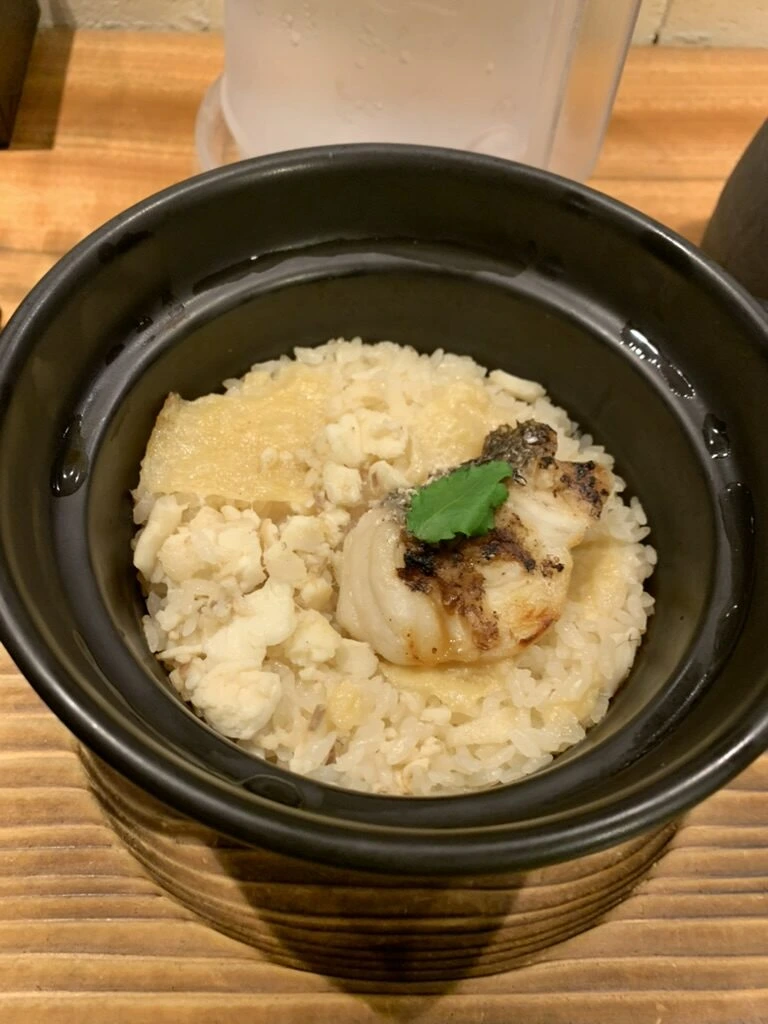 道後の夕食の土鍋ご飯。焼いた白身魚と木の芽がのっている