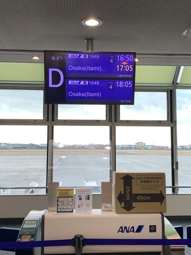松山空港4番搭乗口の案内表示。ANA1646 大阪伊丹行き、出発時刻の変更