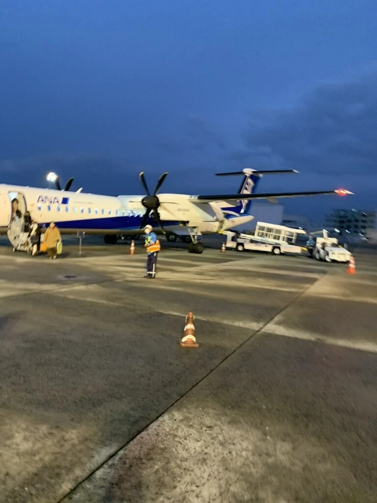 夕暮れの伊丹空港。駐機中のQ400と地上係員