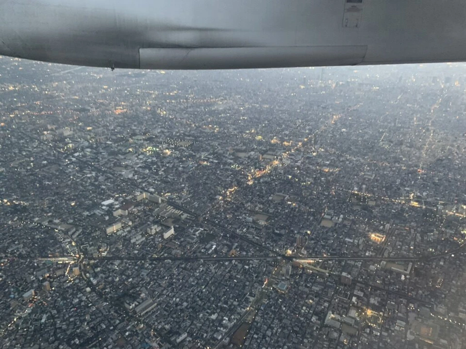 機窓から見た夕暮れの大阪の住宅街。上にQ400の主翼