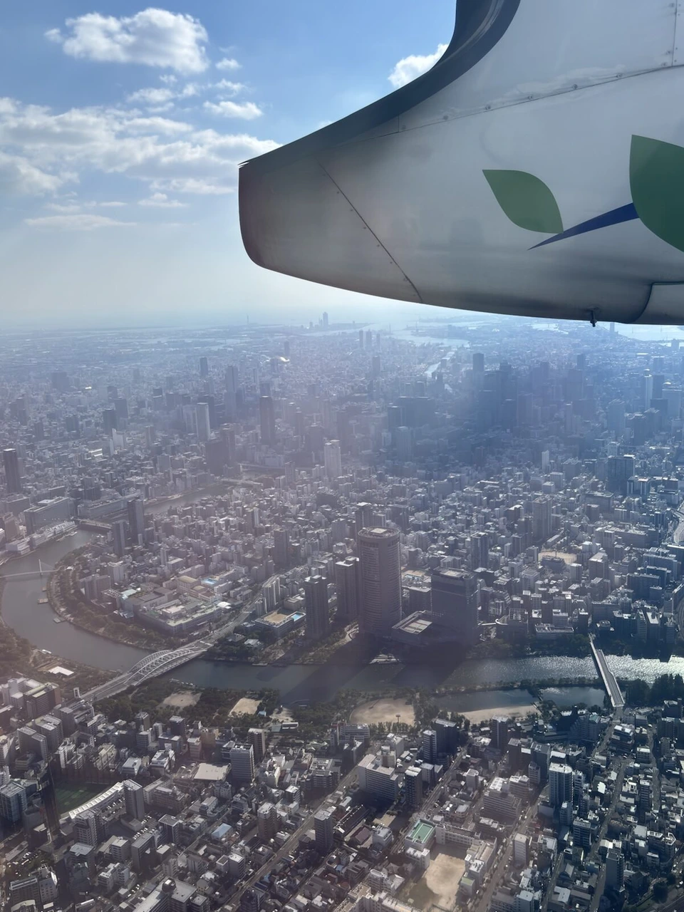 Q400の主翼の下に広がる大阪市街と大阪湾方面