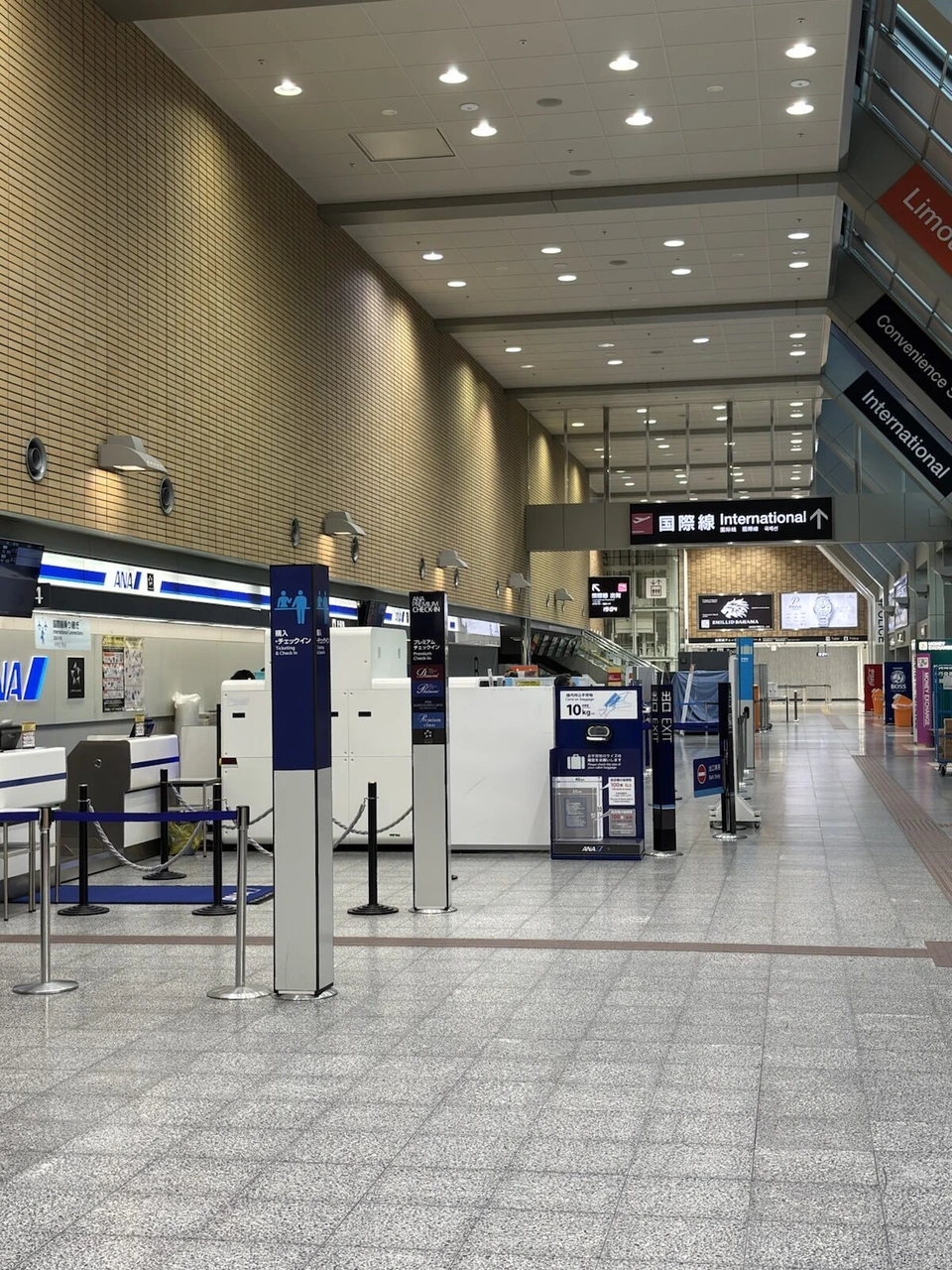 夜の松山空港の出発ロビー。ANAのチェックインカウンターと国際線の案内