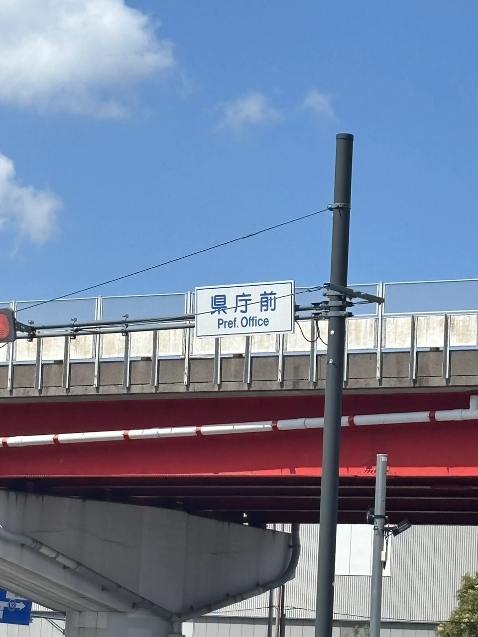 長崎市の県庁前の案内板がかかった歩道橋と青空