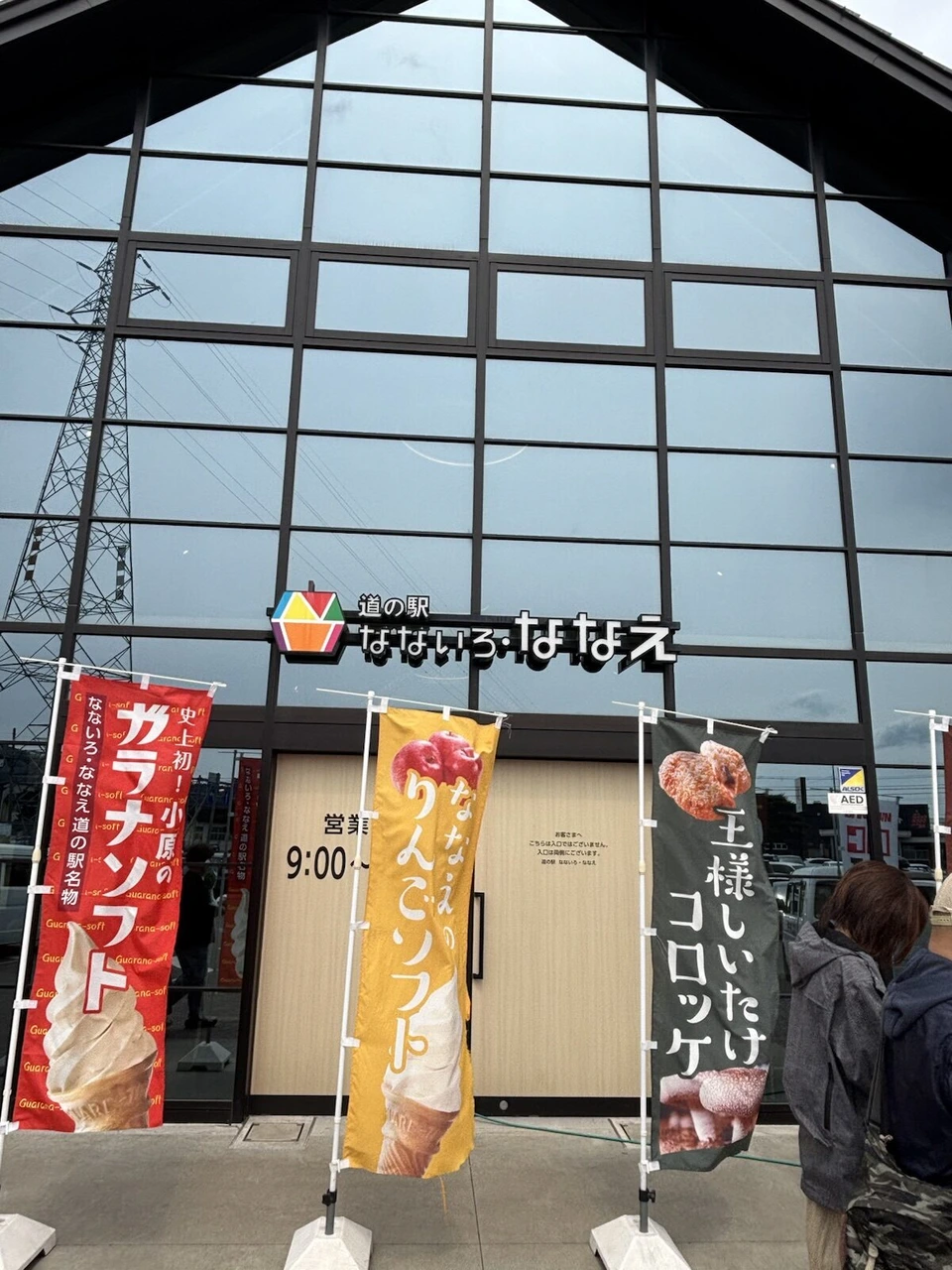 道の駅なないろ・ななえの三角屋根のガラス張り外観と、ガラナソフトやりんごソフトののぼり