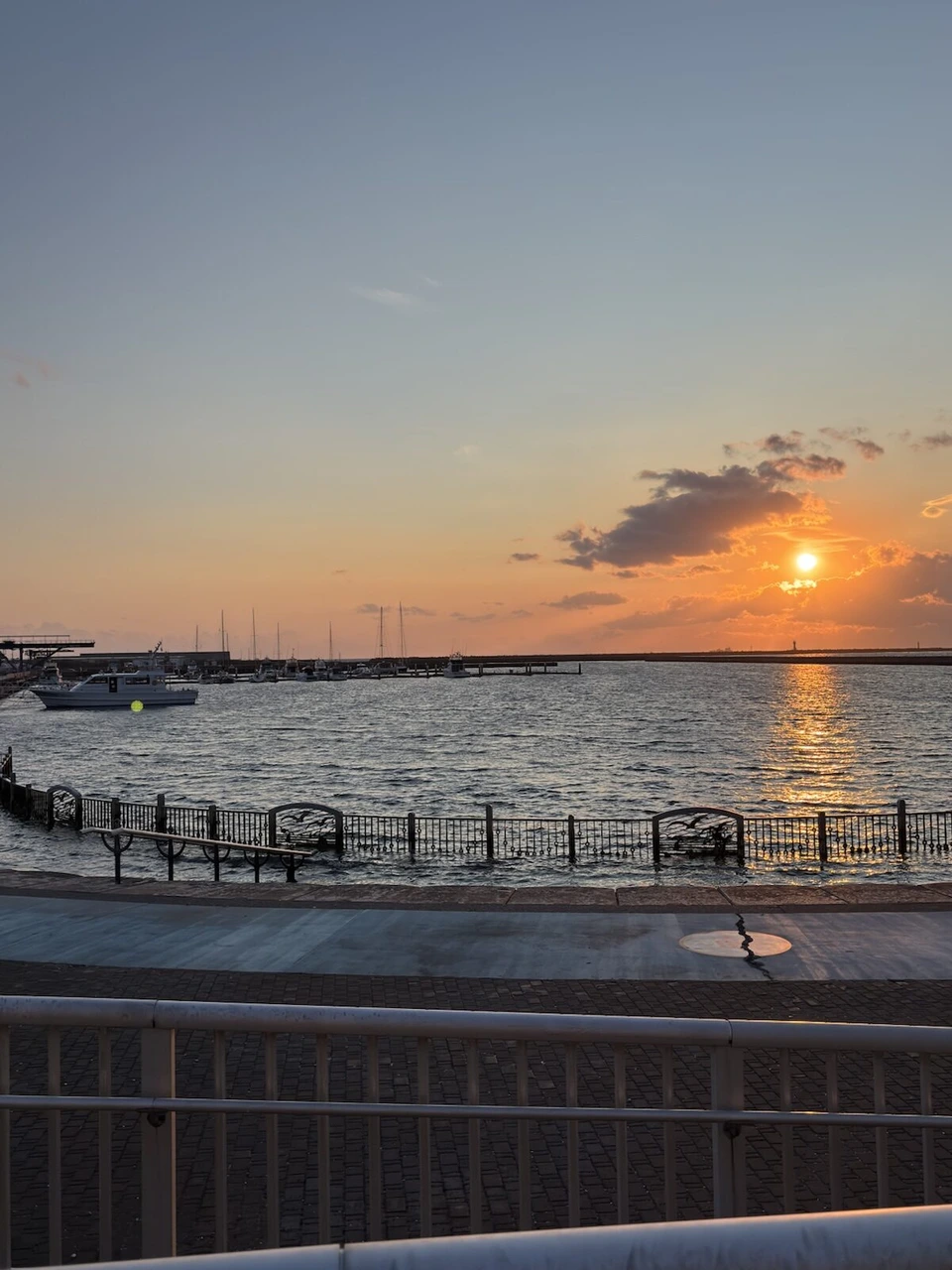 みなとオアシス室蘭の岸壁から見た室蘭港の夕日。海面に夕日の光の道