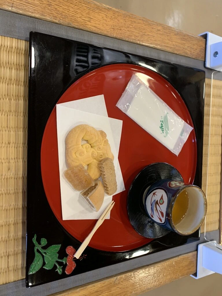 赤い丸盆にのったお茶とお菓子
