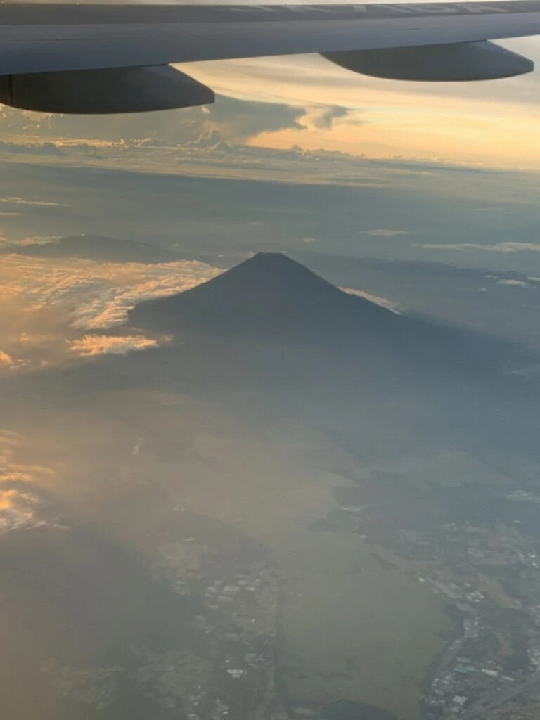 ANA1097便の機窓から見た夕焼けの雲海の中の富士山