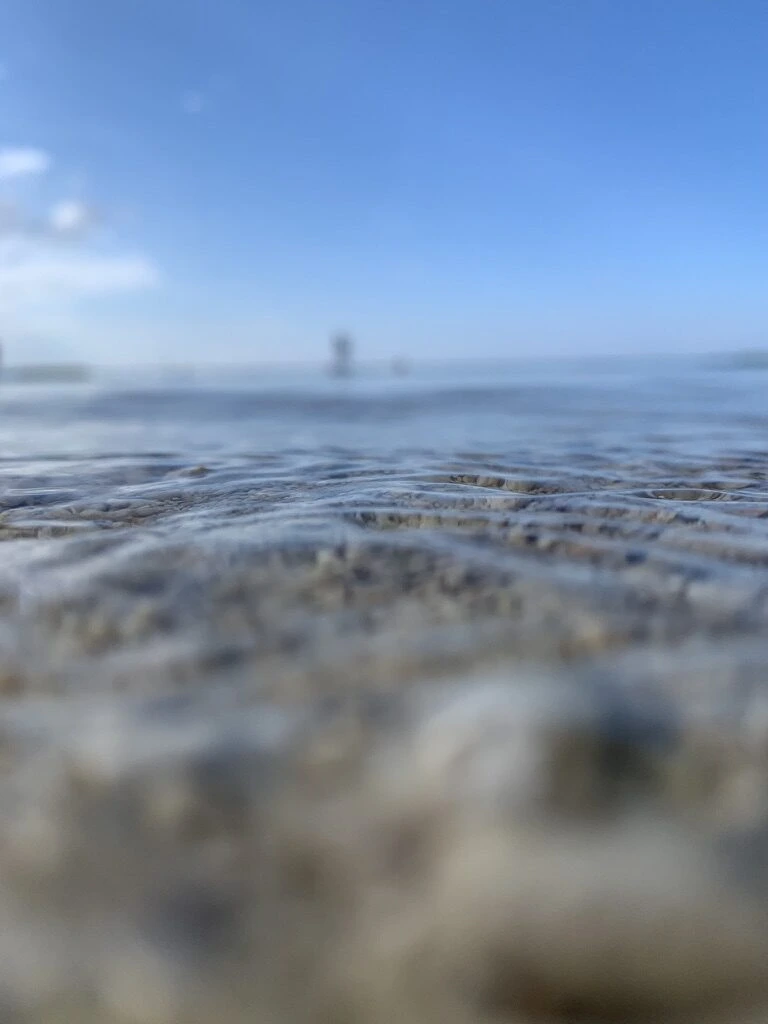 本部町の浜辺の波打ち際すれすれから撮った透明な海