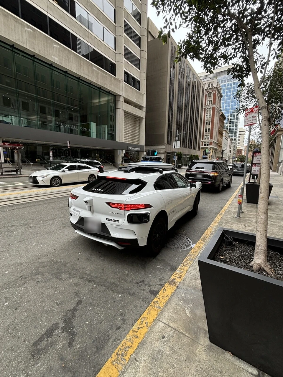 通りを走り去るWaymoの車両の後ろ姿