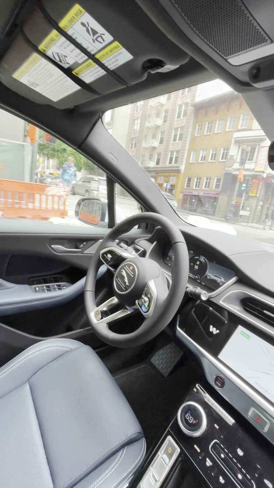 Waymoの車内。誰も座っていない運転席のハンドルとメーター、窓の外のサンフランシスコの通り