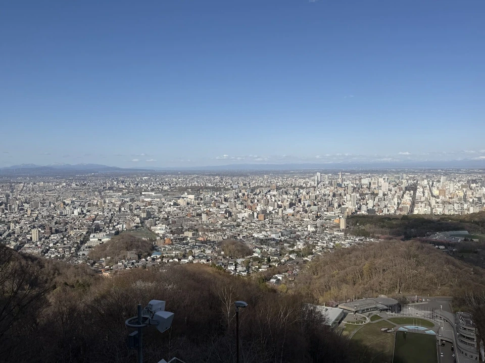 大倉山展望台から横に広く見た札幌の街と、遠くの海