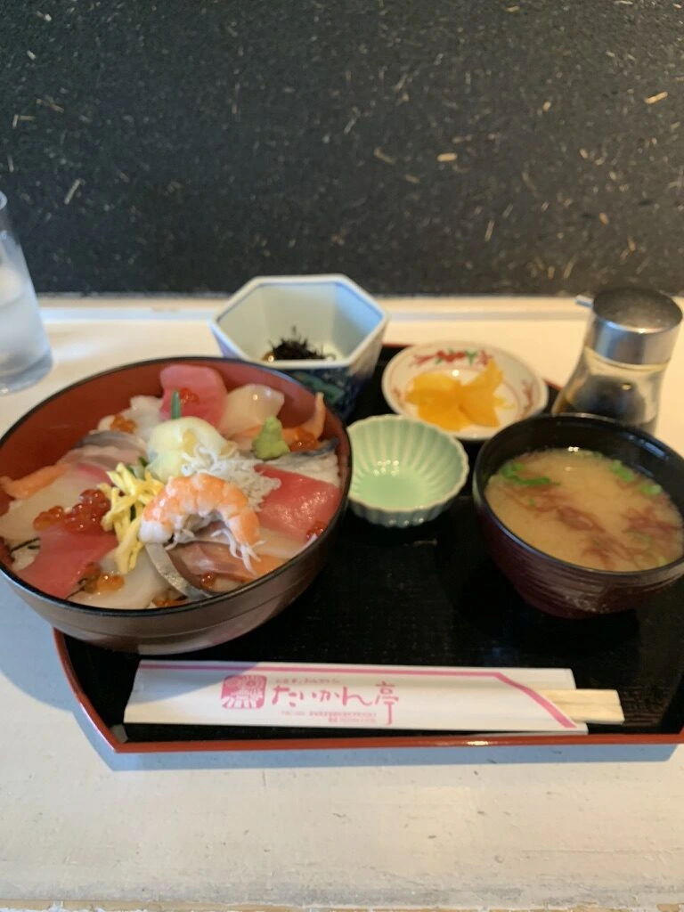 海鮮丼と味噌汁、小鉢のセット。箸袋に「たいかん亭」