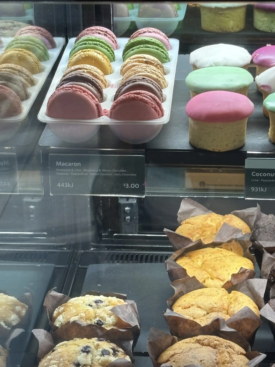シドニーのカフェのショーケースに並ぶカラフルなマカロンとマフィン