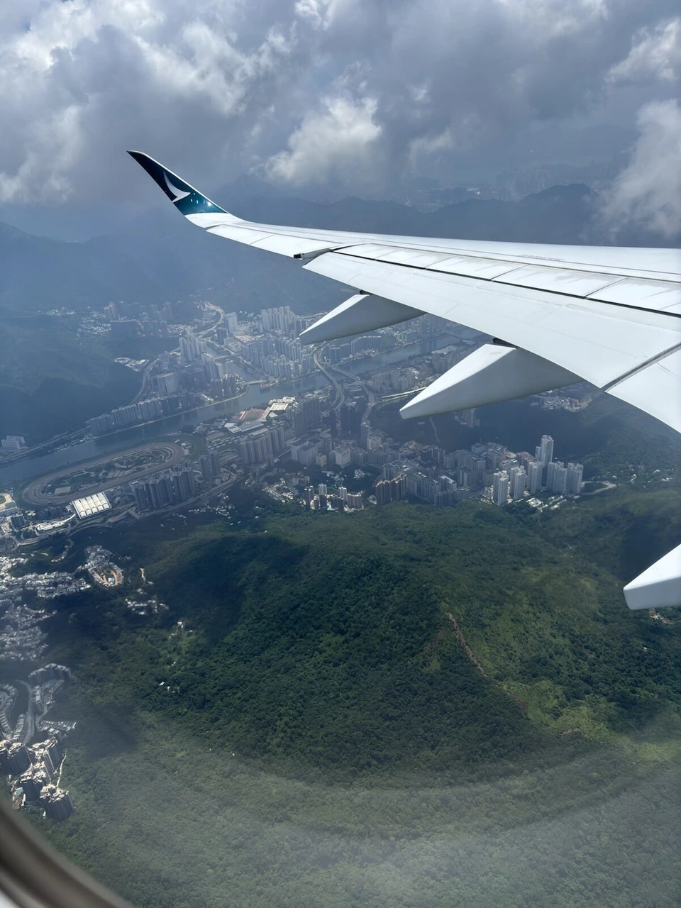 CX503の香港到着直前の機窓。緑の山の向こうに高層住宅が並ぶ