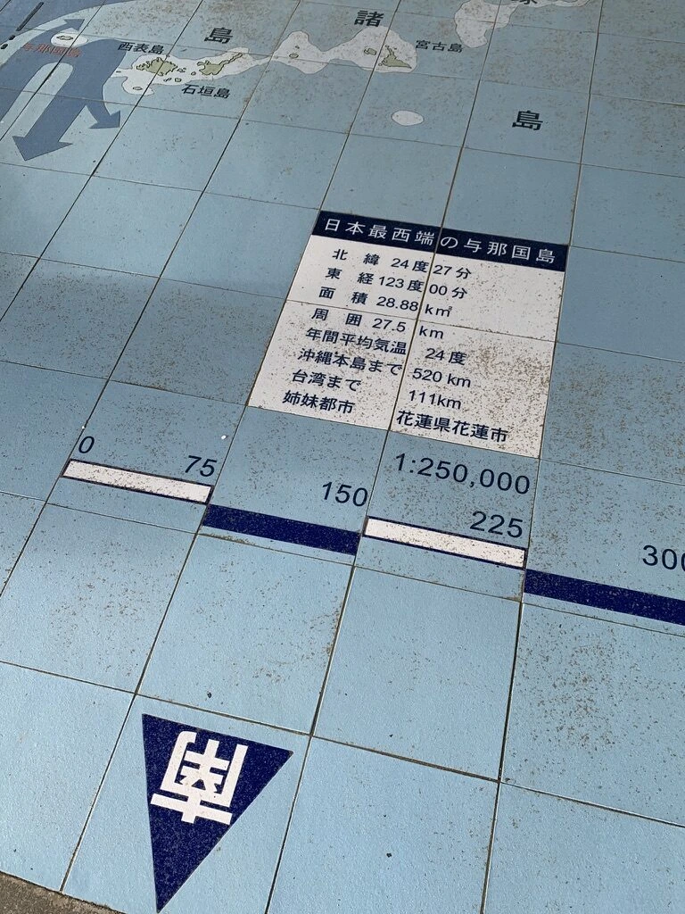 地面のタイル地図。日本最西端の与那国島、北緯24度27分、東経123度00分、台湾まで111kmなどの表示