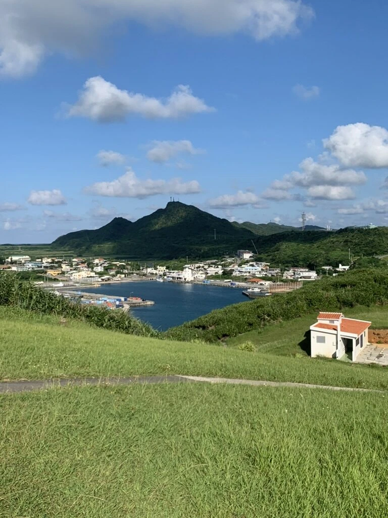 草原越しに見た久部良の港と集落、奥の山