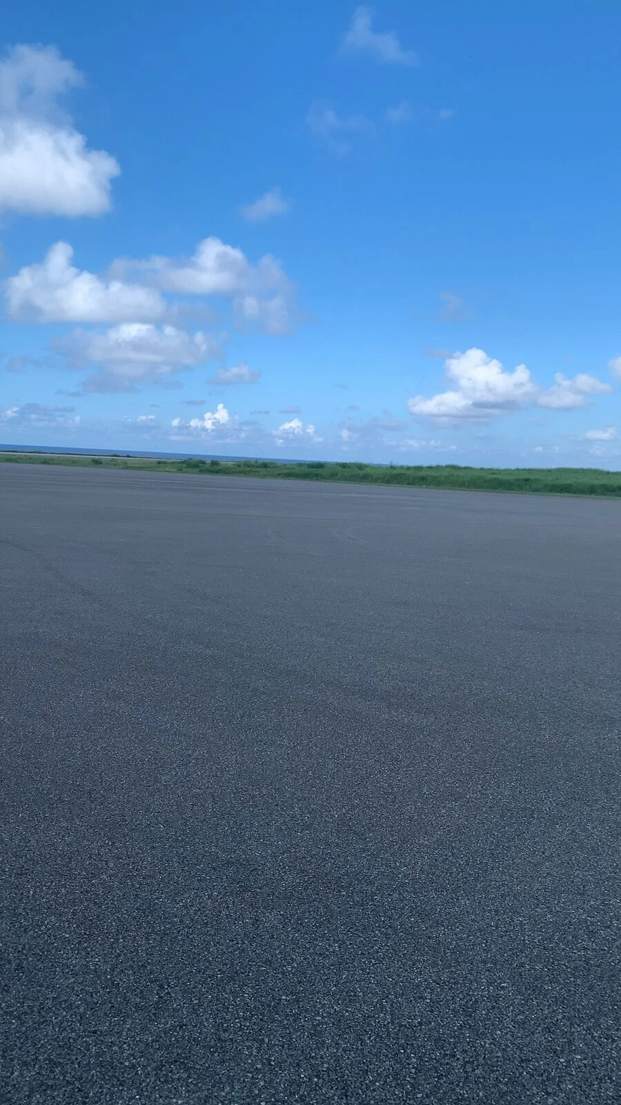 与那国空港の広い駐機場と、奥の草原と青空
