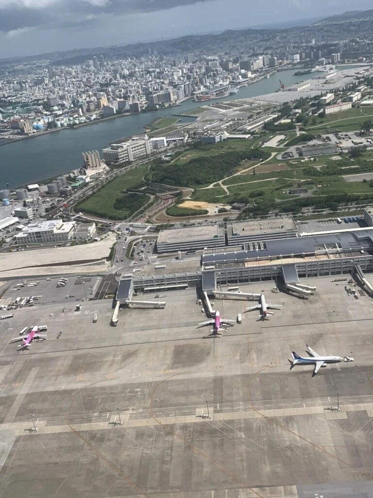 那覇を離陸した直後の機窓から見た那覇の街と海